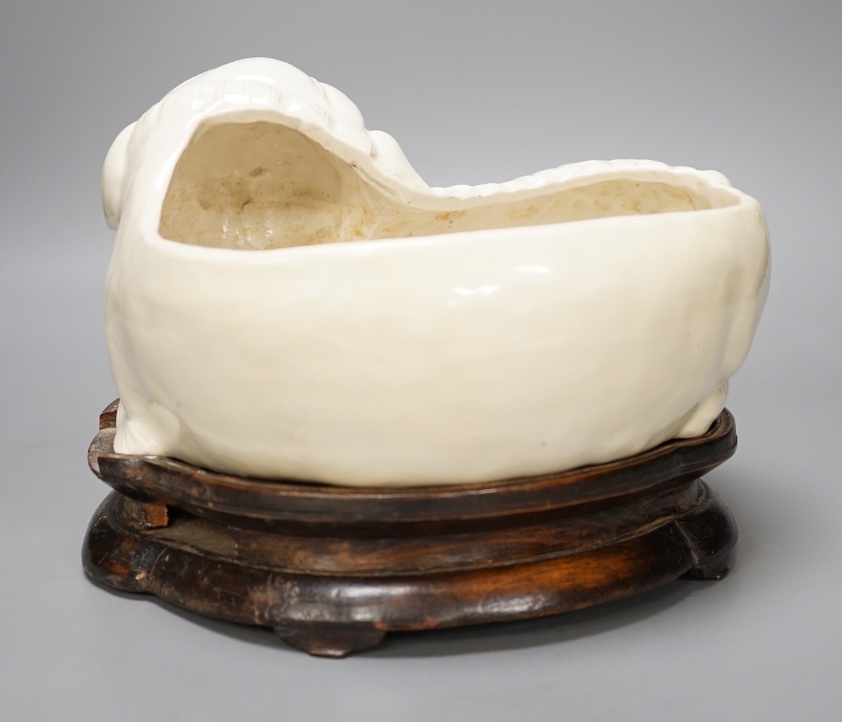 A Chinese cream glazed lion’dog planter on hardwood stand, 21cm